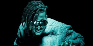 flying-lotus-in-water-up-to-his-chest-with-dreads-and-glasses.jpg