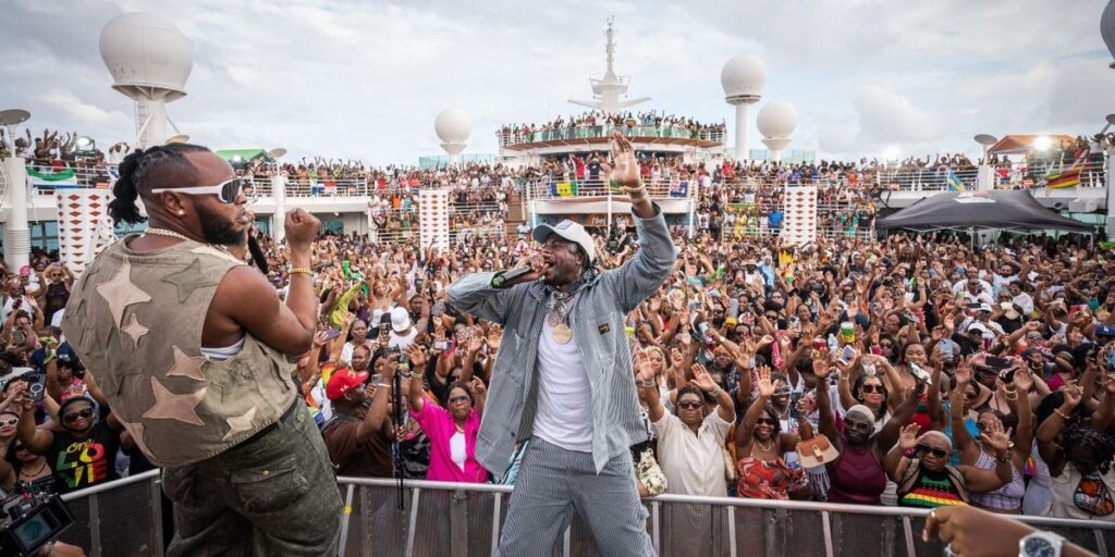 on-a-cruise-ship-top-deck-a-large-crowd-of-people-gathers-around-a-man-on-stage-with-a-microphone.jpg