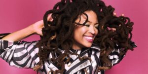 a-black-woman-with-a-huge-smile-holding-her-hair.jpg