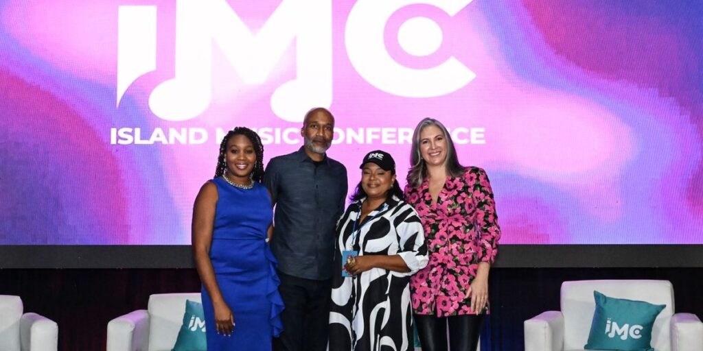 a-group-of-execs-standing-in-front-of-an-on-stage-pannel.jpg