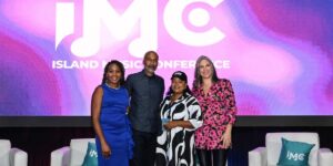 a-group-of-execs-standing-in-front-of-an-on-stage-pannel.jpg