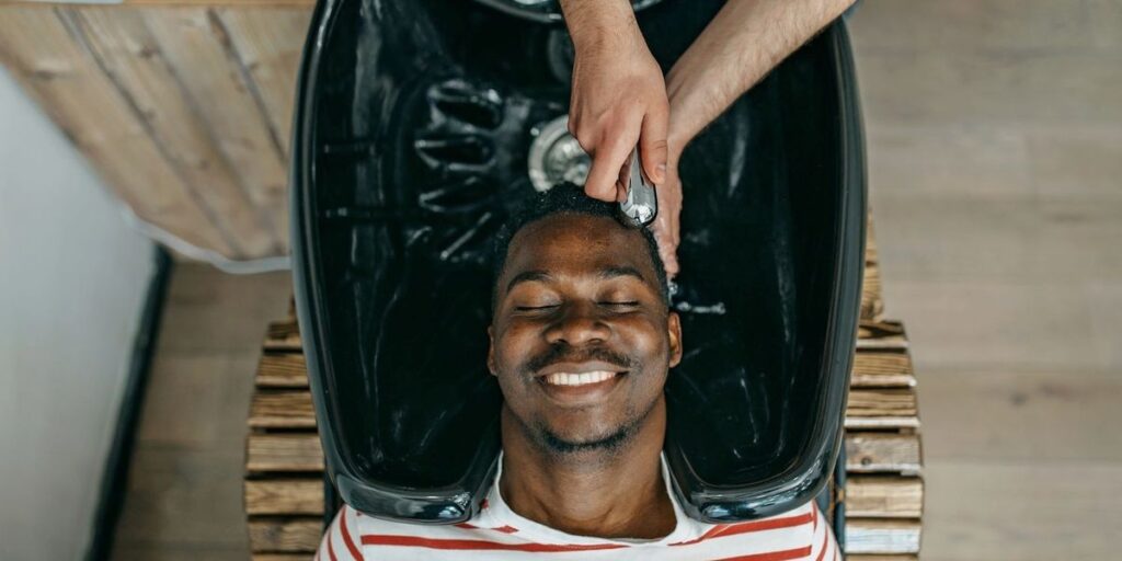 a-smiling-black-man-has-his-hair-washed-at-the-barber.jpg