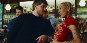 jack-harlow-and-doja-cat-leaning-against-a-bar-and-looking-at-each-other.png