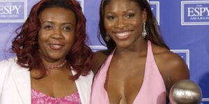serena-and-her-sister-posing-for-a-photo-wearing-pink-and-holding-a-trophy.jpg