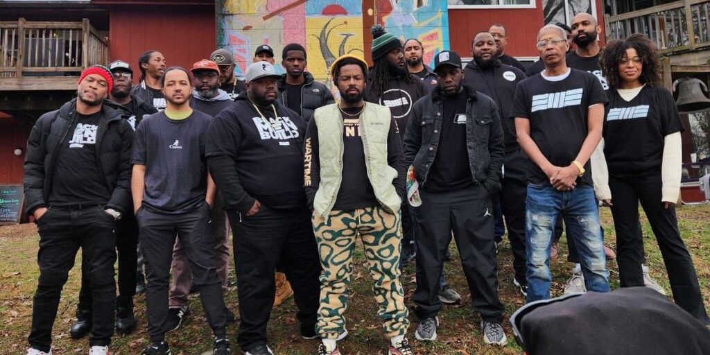a-group-of-black-men-stand-together-outside-a-street-mural.jpg