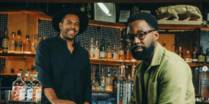 two-black-men-smiling-at-a-nicely-designed-bar.png