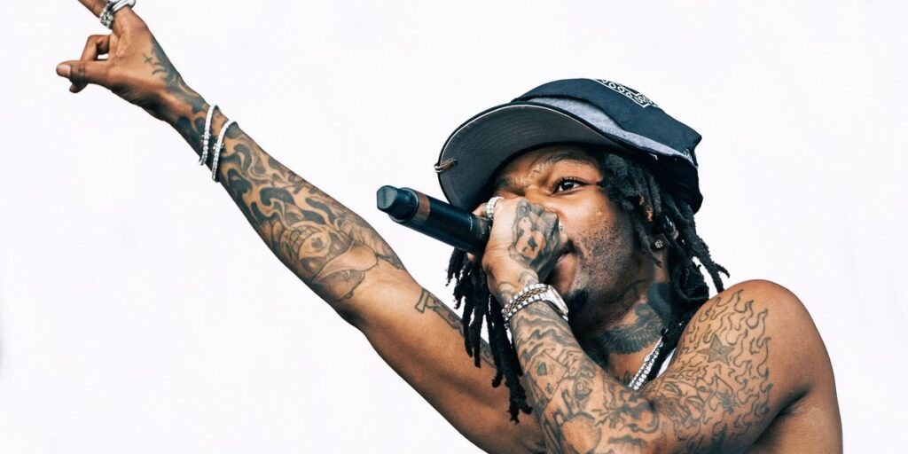 jid-makes-a-peace-sign-towards-the-sky-in-a-white-tank-top.jpg