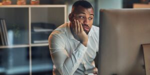 shot-of-a-young-businessman-looking-bored-while-working-at-his-desk-during-late-night-at-work.jpg